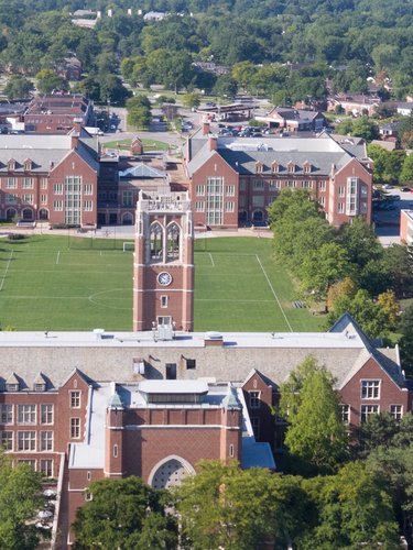 Aerial view of a red brick university campus surrounded by trees.