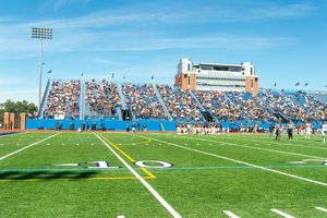 View of Don Shula Stadium filled with spectators watching a football game on a sunny day.