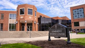 View of the Lombardo Student Center building at John Carroll University with a sign in the foreground and students near the