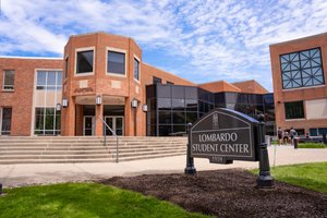 View of the Lombardo Student Center building at John Carroll University with a sign in the foreground and students near the