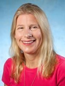 A smiling woman with long blonde hair wearing a bright pink top against a blue gradient background.