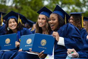 Commencement Graduates Holding Diplomas