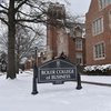 A snow-covered campus scene shows a black sign reading Boler College of Business in front of a red brick building and