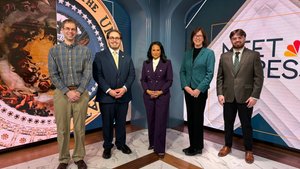 Five people stand side by side on a marble floor in front of large digital screens displaying a seal and the text Meet Press.