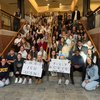 Joyful nursing students celebrate their program’s full accreditation on a university staircase