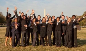 group of people in suits in front of the Washington monument