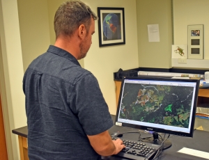 Watling stands in his lab at a computer and analyzes mapping data