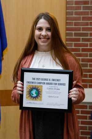 Caitlin Drake '22 holding the Campion Award Certificate