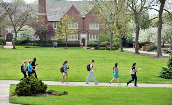 Students walking across campus on a spring day