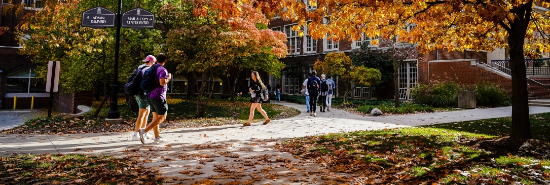 JCU students walking across campus with fall leaves 