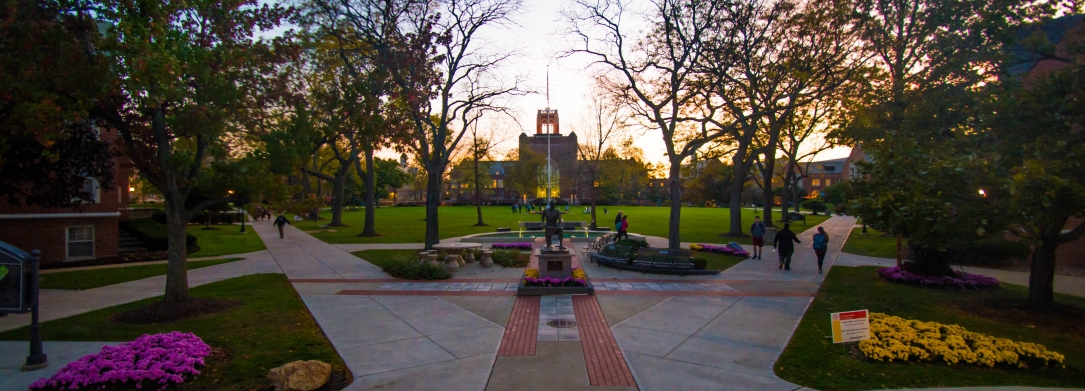 Image taken at dusk of the St. Ignatius statue and quad from the front steps of the Student Center 