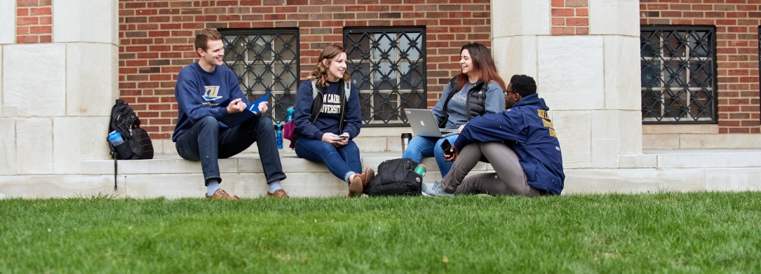 students sitting on steps on campus
