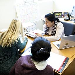 Female faculty member helping two female students during office hours