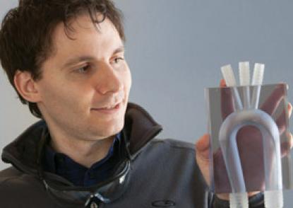 Malinskiy holds a 1-to-1 aortic arch model with a cardiac catheter inside it.