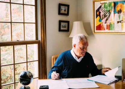 Bill O’Rourke sits at the desk in his home office