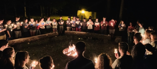 Group of students holding candles on a retreat.